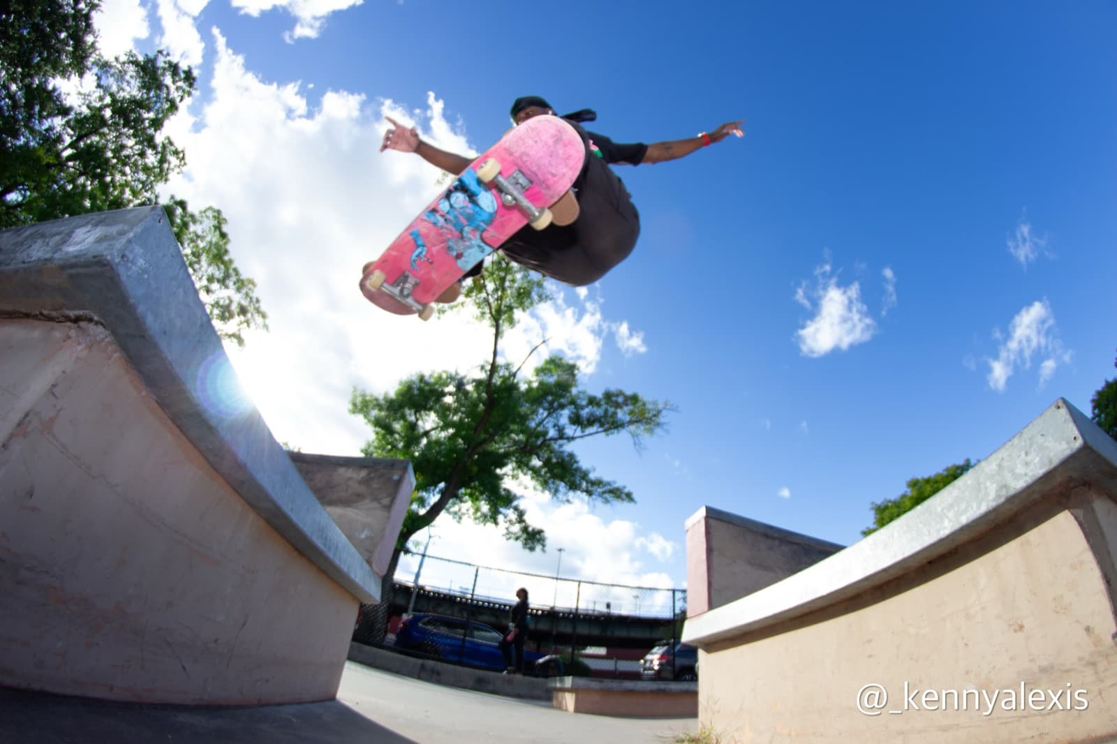 Leon Toppin launching an aerial trick between concrete ramps at a skatepark