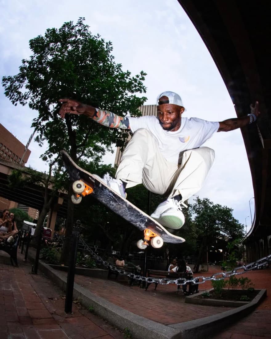 Leon Toppin mid-ollie over a chain barrier near the Lower East Side