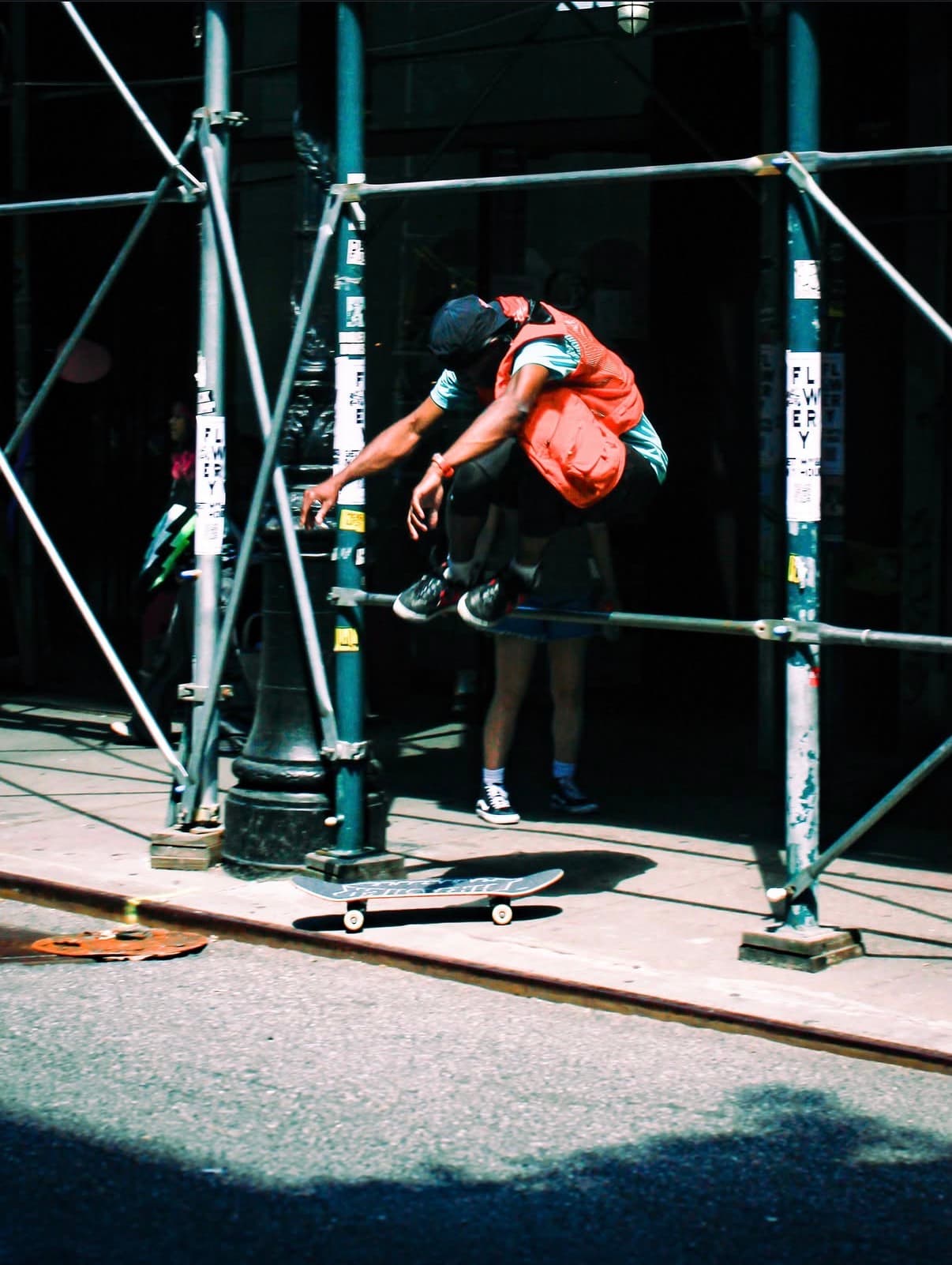 Leon Toppin performing a skateboard trick on a New York City sidewalk
