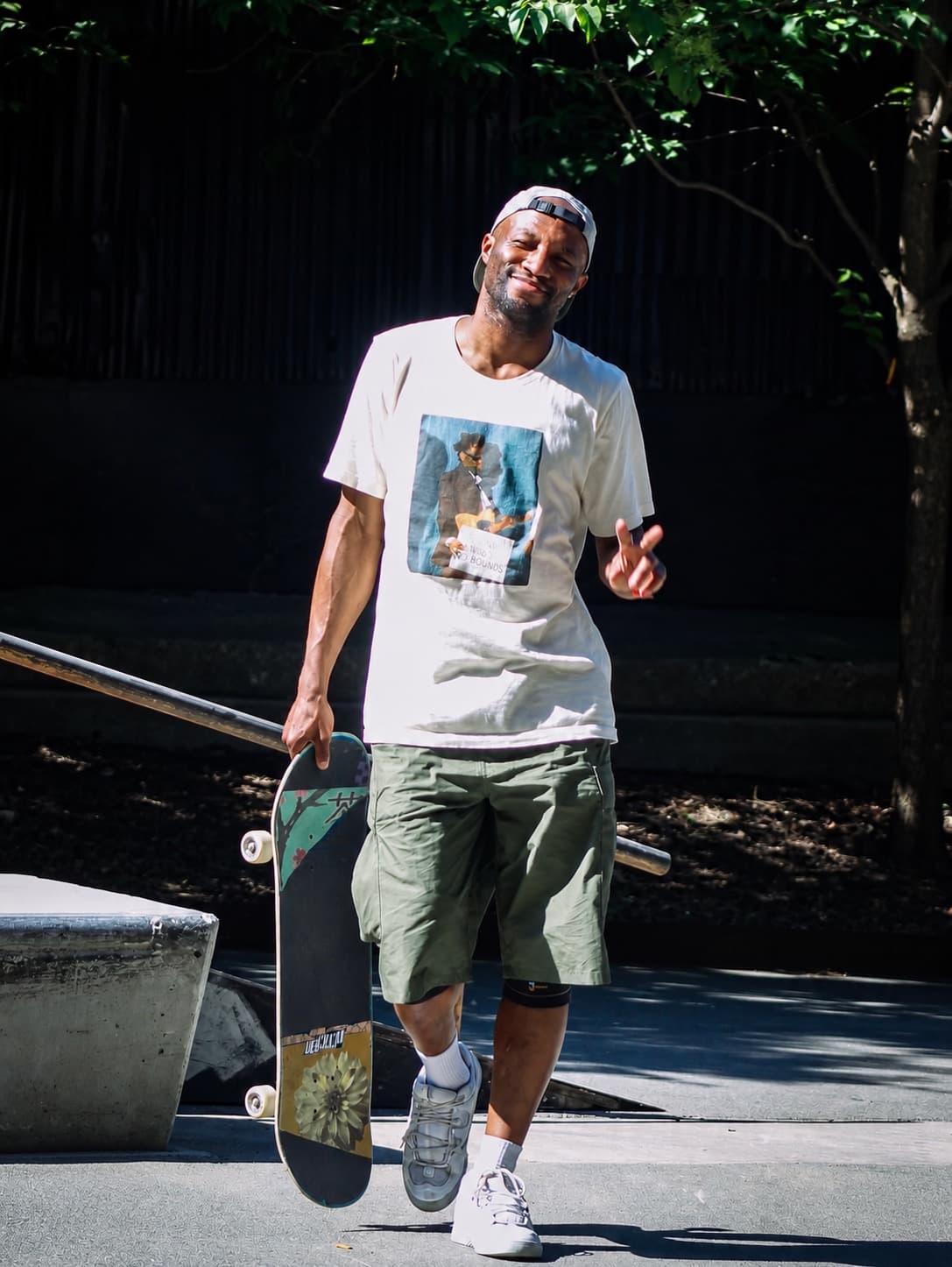 Leon Toppin smiling and holding his skateboard at a skatepark