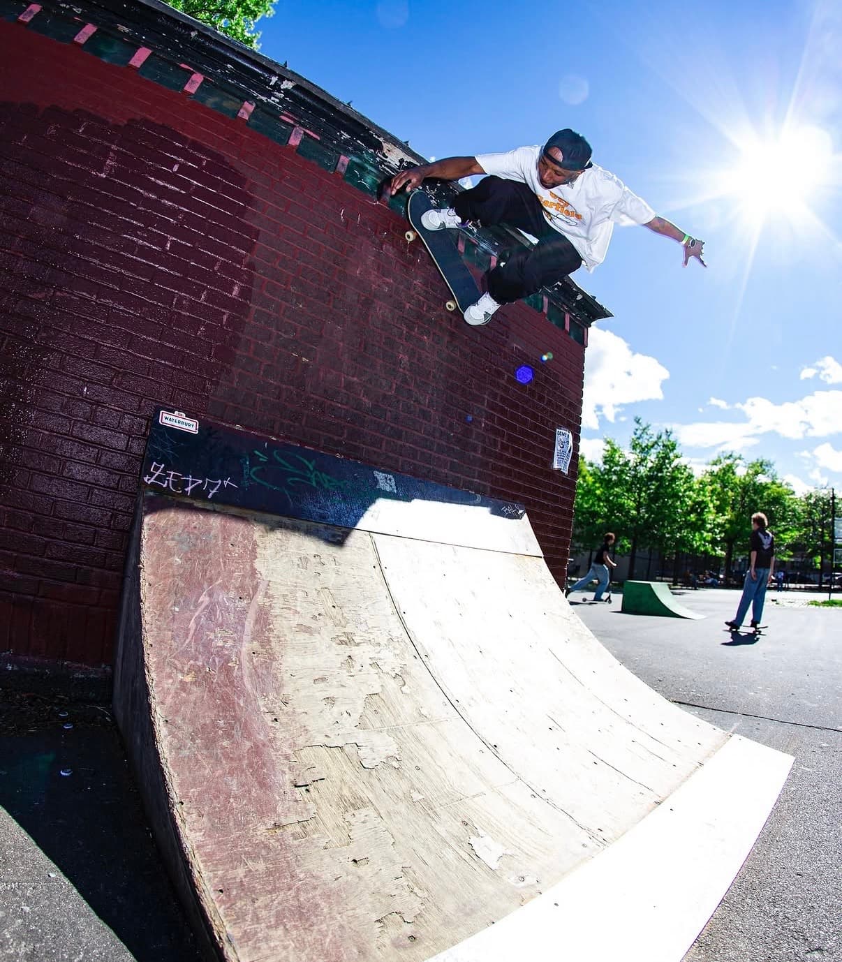 Leon Toppin doing a wallride at a sunny skatepark